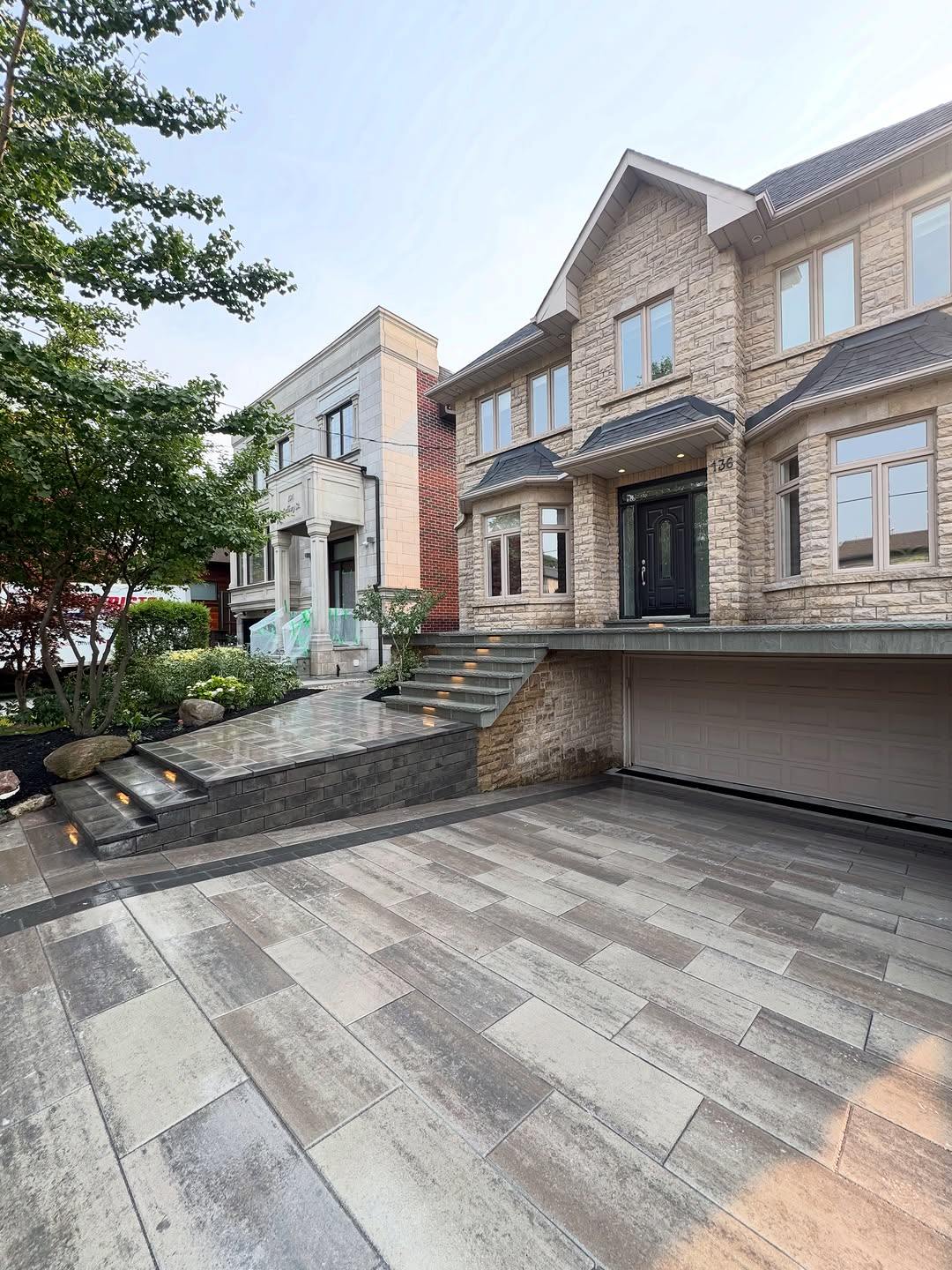 New interlock driveway and stone steps in front of a stone house