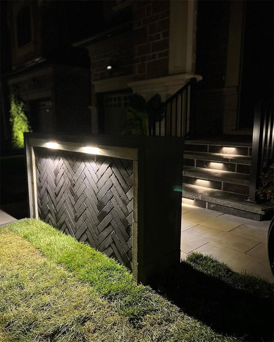 Lit herringbone stone wall at night
